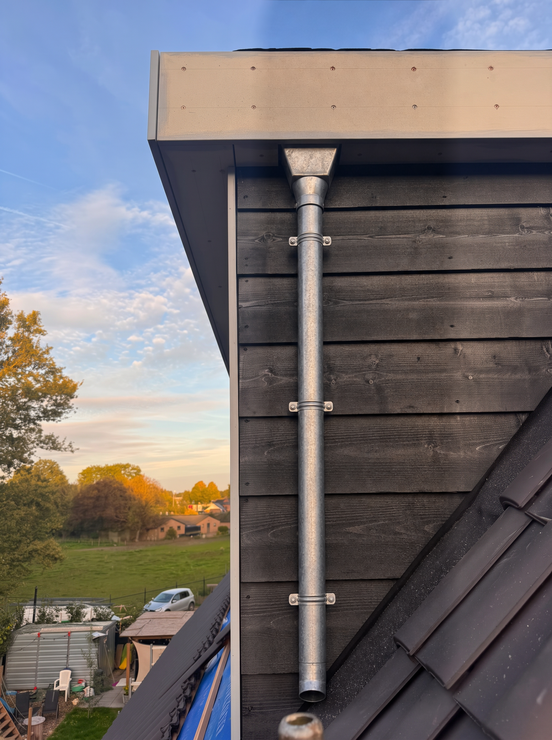 Nieuwe dakkapel met zwarte houten bekleding en zinken regenpijp